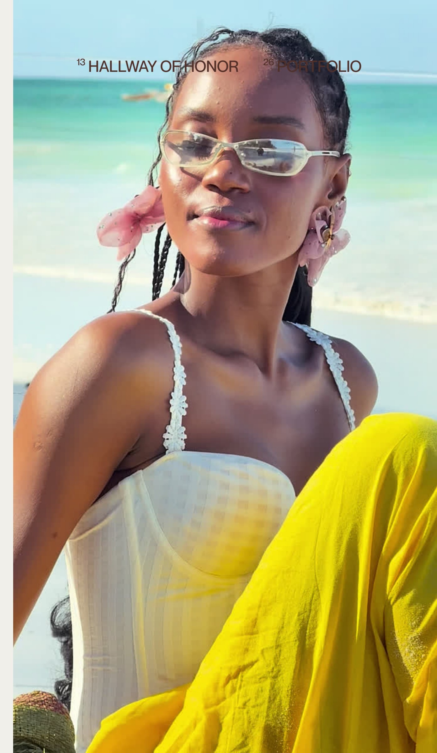 ZEE campaign photograph: a woman in sunglasses, a white top and a yellow skirt photographed on a beach